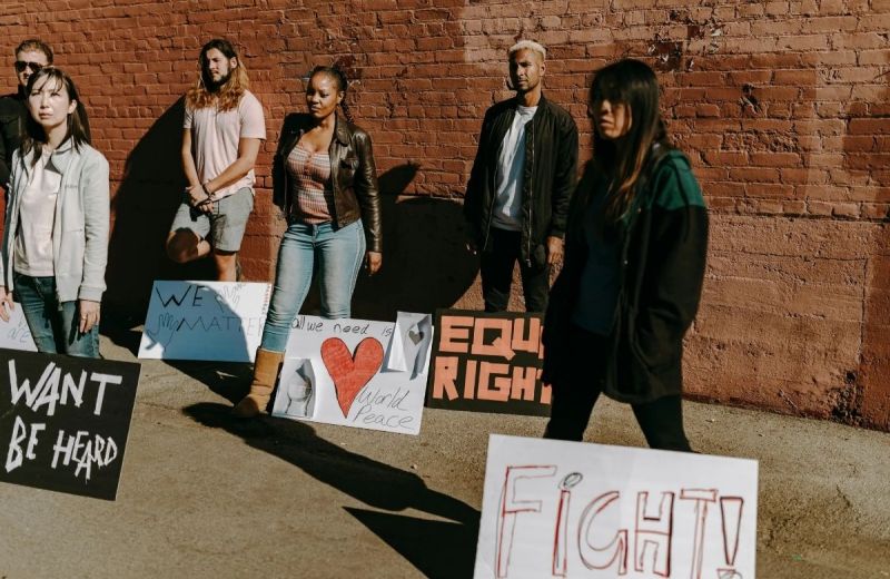 Samling av ungdomar med skyltar för rättvisa och fred, uttrycker engagemang och allvar.