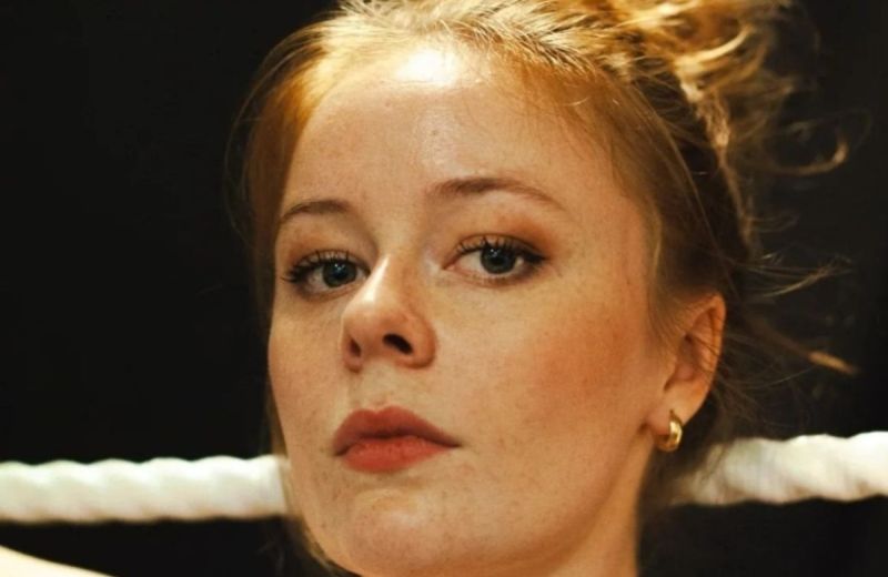 Porträtt i närbild av Maja Fock med uppsatt hår och ett vitt rep i bakgrunden.